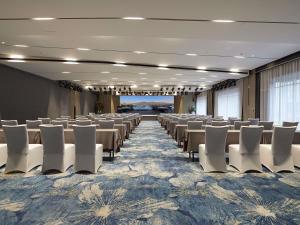 a banquet hall with rows of tables and white chairs at Mercure Tai'an Centre in Tai'an +54 photos