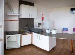 a kitchen with white cabinets and a counter top at GarçaView in Vila Franca do Campo +32 photos