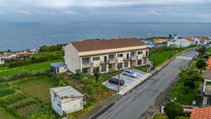 a house on the side of a road next to the ocean at GarçaView in Vila Franca do Campo