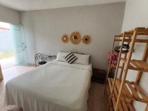 a bedroom with a white bed and a wooden ladder at Solares Boa Estada in Búzios