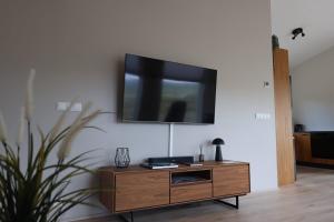 a living room with a tv on a wall at Hvammur 10 with private hot tub in Kaldrananes