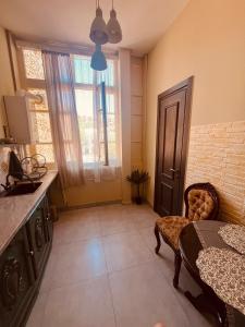 a kitchen with a table and a chair in a room at One bedroom apartment in Tbilisi City