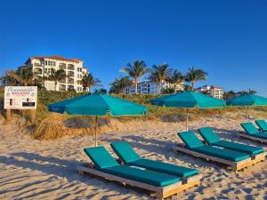 a group of chairs and umbrellas on a beach at Ocean Pointe Resort One-Bedroom Villa in Palm Beach Shores +27 photos