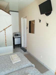 a bedroom with a bed and a tv on the wall at Le ti'Roussat in Saint-André-de-Cubzac