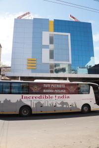un autobús está estacionado frente a un edificio en Kani Residency Hotel, en Thoothukudi