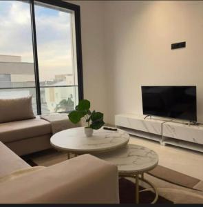 a living room with a couch and a table at Résidence Jasmin in Harqalah +24 photos