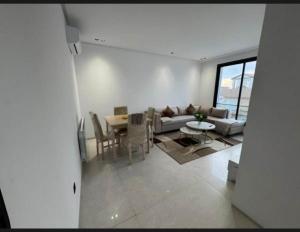 a living room with a couch and a table at Résidence Jasmin in Harqalah