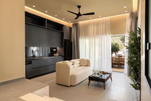 ein Wohnzimmer mit weißem Sofa und eine Küche in der Unterkunft Mitos Ultimate Escape Villa in Galanádhon