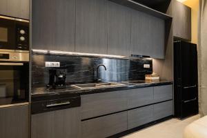 eine Küche mit Spüle und Mikrowelle in der Unterkunft Mitos Ultimate Escape Villa in Galanádhon