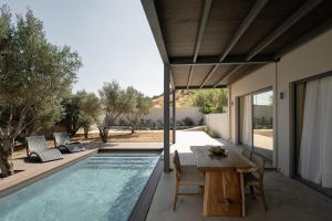 eine Terrasse mit Tisch und ein Swimmingpool in der Unterkunft Mitos Ultimate Escape Villa in Galanádhon