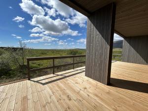 a wooden deck with a view of a field at Brúarárbyggð A2 in Blaskogabyggo