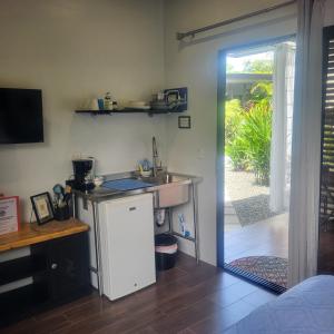 a kitchen with a sink and a sliding glass door at MADRE TERRA in Uvita