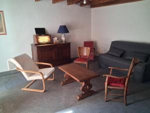 a living room with chairs and a table and a couch at Logis de Rocles in Rocles