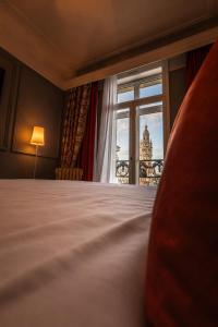 a bedroom with a bed and a view of a building at Grand Hotel Bellevue - Grand Place in Lille +34 photos
