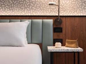 a bedroom with a bed and a table with a lamp at Novotel Malta Sliema in Il-Gżira +164 photos