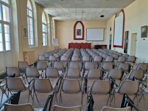 an empty room with chairs and a screen in the middle at Centre Louis Ormières in Montauban