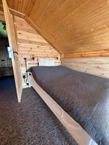 a bedroom with a bed in a wooden room at Monialuki in Nogat