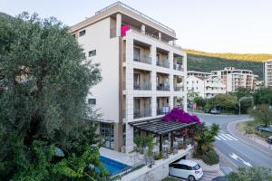 an apartment building with a balcony and a street at Hotel Petrovac in Petrovac na Moru