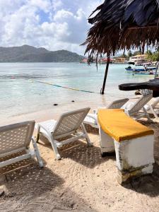 ein Tisch und Stühle an einem Strand mit dem Wasser in der Unterkunft Hotel Cocotal in Isla Grande