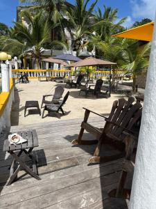 eine Holzterrasse mit Stühlen und einem Tisch am Strand in der Unterkunft Hotel Cocotal in Isla Grande