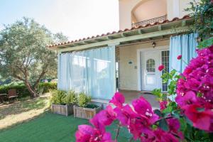 a house with a yard with pink flowers at Ilios house in Achladies