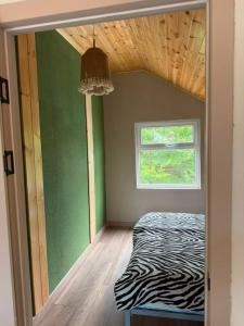 a room with a zebra print bed and a window at The Barn in Cholpon-Ata