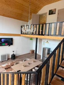a living room with a wooden table and a staircase at The Barn in Cholpon-Ata