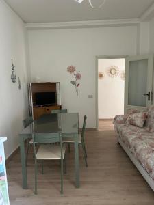 a living room with a glass table and a couch at MareMare Follonica in Follonica
