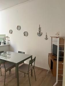 a dining room with a table and chairs and a tv at MareMare Follonica in Follonica