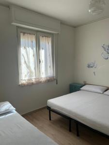 a bedroom with two beds and a window at MareMare Follonica in Follonica