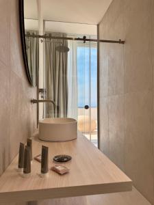 a bathroom with a sink and a mirror at Fenici Levanzo Hotel - Adults Only in Levanzo +48 photos