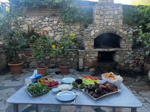 a table with plates of food and a stone oven at Manes in Yeghegnadzor