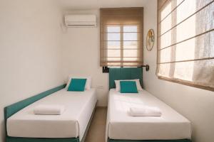 two beds in a room with two windows at GABRIEL APARTMENTS - Jacuzzi & Panoramic JLM View Steps to Shaare Zedek Hospital in Bayit Wegan
