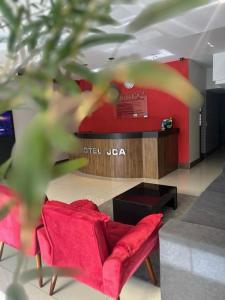 a living room with a red couch and a red wall at Hotel JCA Uberlândia in Uberlândia