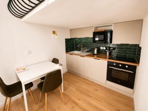 a small kitchen with a white table and chairs at Cosy-T2 - Hyper centre Montpellier in Montpellier
