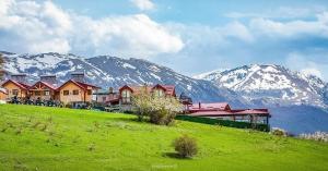 a group of houses on a hill with snow covered mountains at Kompleks MINAMI in Ohrid
