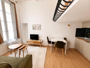 a living room with a table and chairs and a tv at Cosy-T2 - Hyper centre Montpellier in Montpellier
