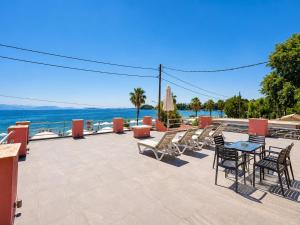 a patio with a table and chairs and the ocean at Alexandra Apartment in Ipsos