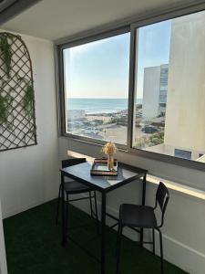 a table and two chairs in a room with a window at Saint Hilaire sea view accommodation in Saint-Hilaire-de-Riez