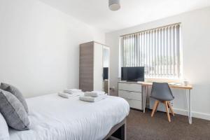 a bedroom with a bed and a desk with a computer at Doncaster Budget Room in Shared House w Kitchen in Doncaster