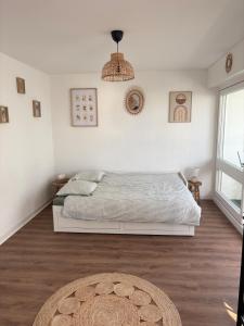 a white bedroom with a bed and a rug at Saint Hilaire sea view accommodation in Saint-Hilaire-de-Riez