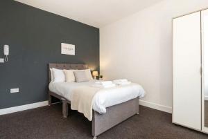 a bedroom with a large bed with white sheets at Doncaster Budget Room in Shared House w Kitchen in Doncaster