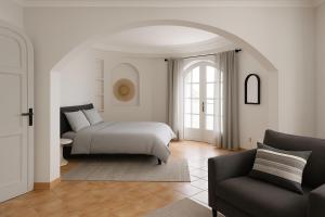 a bedroom with a bed and a chair at Dar 'Villa Blanche' in Djerba +14 photos