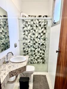 a bathroom with a shower and a toilet and a sink at Hotel JCA Uberlândia in Uberlândia