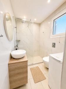 a white bathroom with a sink and a shower at Alexandra Apartment in Ipsos +38 photos