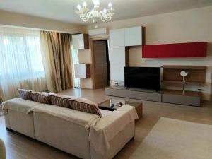 a living room with a couch and a flat screen tv at HERASTRAU APARTMENTS 3 camere self check-in in Bucharest