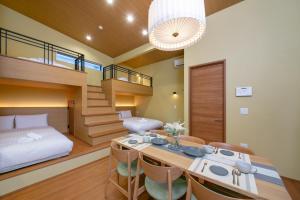a room with a bed and a table and chairs at T-home彩 in Tokyo