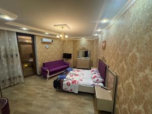 a bedroom with a bed and a purple couch at Mountain-city in Zaqatala