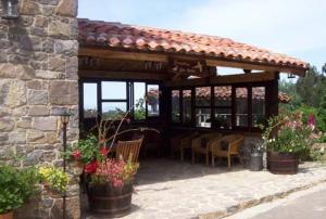 a pavilion with a table and chairs and flowers at Casa de Aldea Los Valles in La Llera