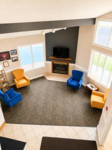 a living room with blue chairs and a television at Days Inn by Wyndham Hinckley in Hinckley